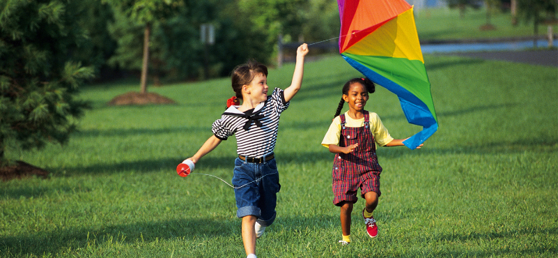 children running with rainbow kite