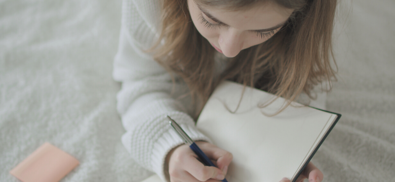 blond teen writing in her journal