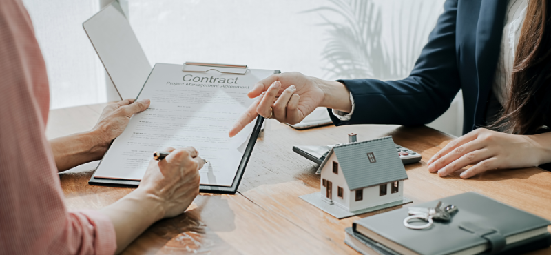 Woman signing contract after selling the house in a divorce