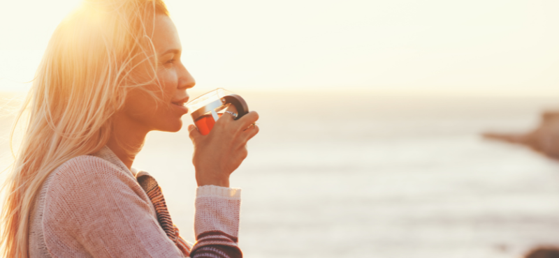 woman on beach drinking tea