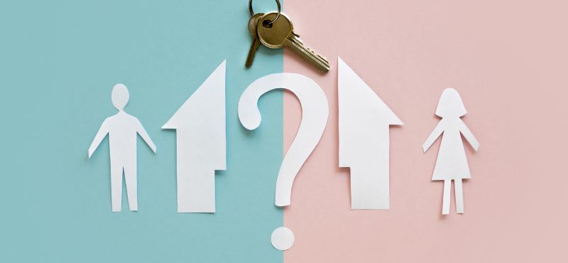 paper cut outs of man, woman, and a question mark betwen a house cut down the middle. blue background on the left, pink on the right, keys above the question mark