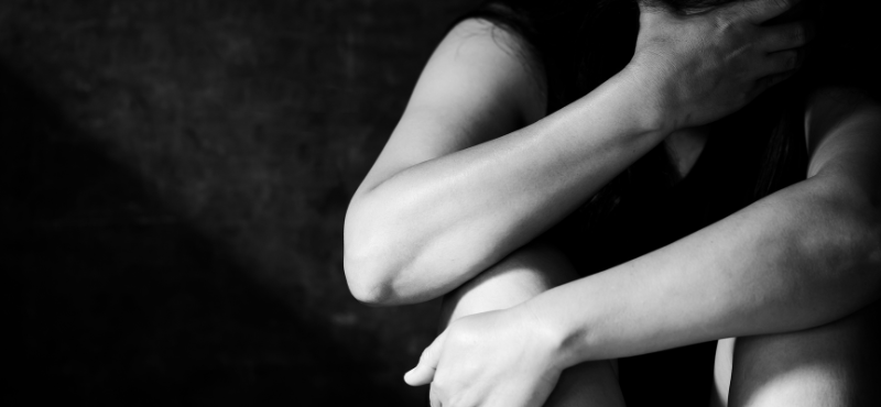 photo in black an white of a woman hugging knees