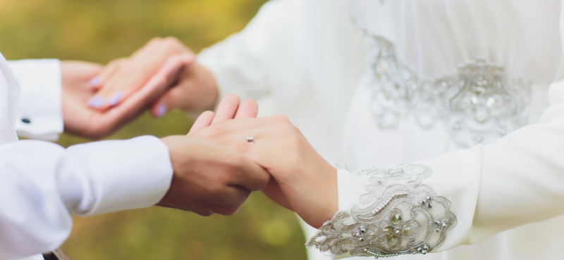 closeup of bride holding groom's hand