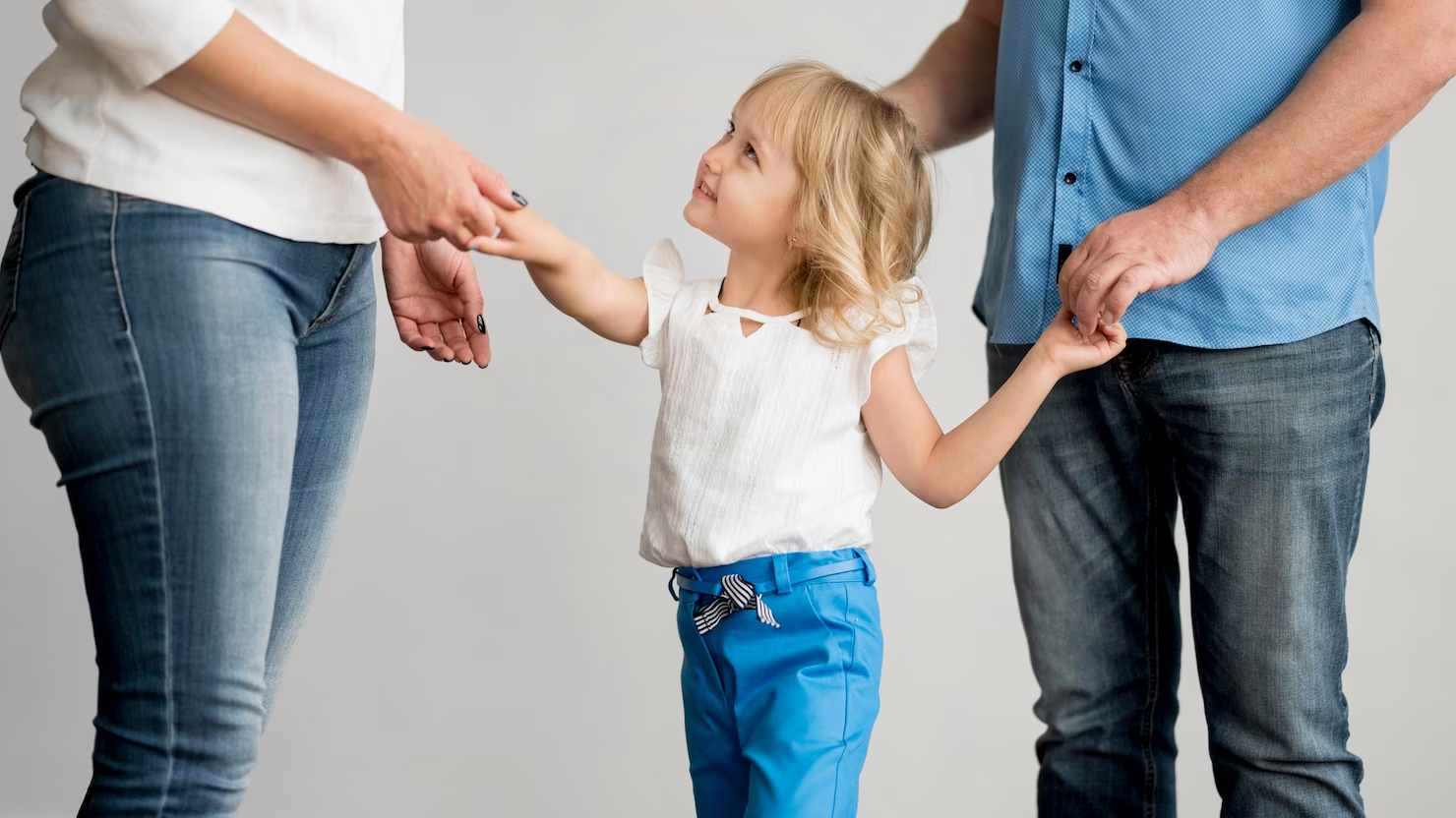 Child holding hands with parents